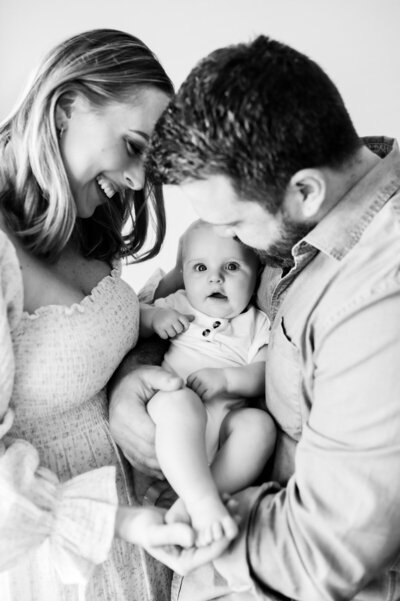 mom and dad holding baby