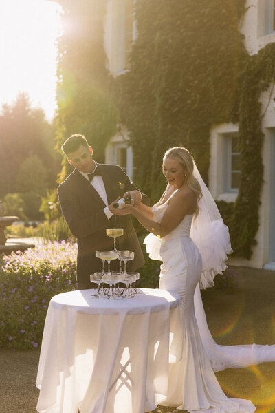 Elegant wedding couple pouring champagne into a glass