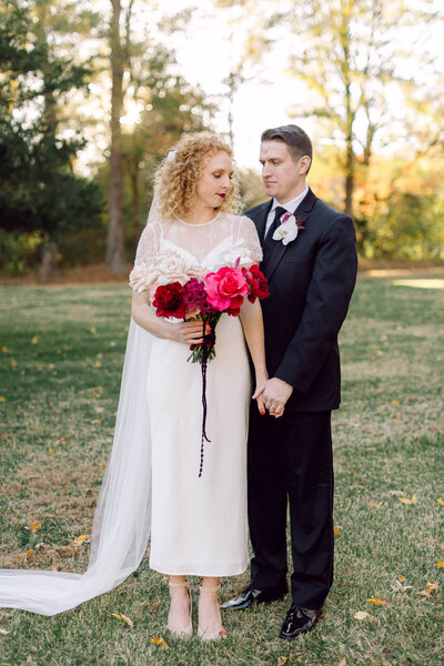 Bride and groom holding hands during their heartfelt backyard wedding ceremony in Richmond, Virginia, captured in an intimate documentary-style moment.
