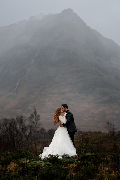 Couple  kiss during their scottish elopement to glencoe