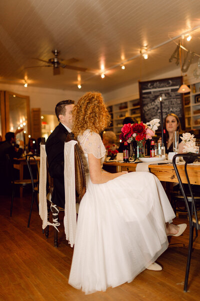 Bride seated during a quiet moment at her intimate backyard wedding reception in Richmond, Virginia.
