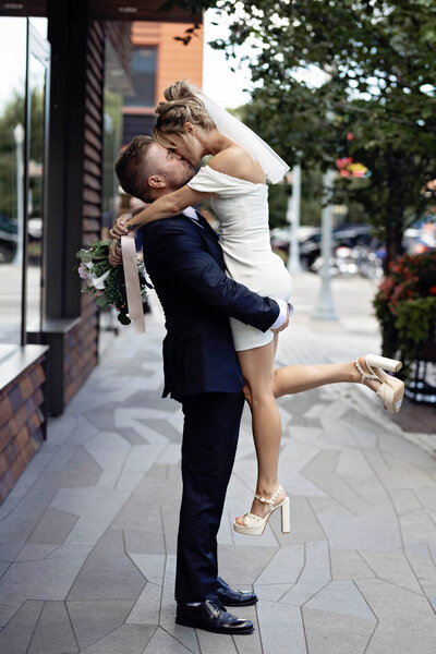 a couple kissing and hugging after they just eloped in downtown aspen