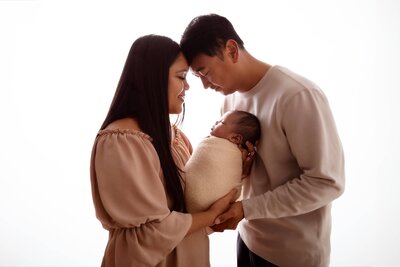 Parents portraits holding baby during a newborn session in Summerside Edmonton.