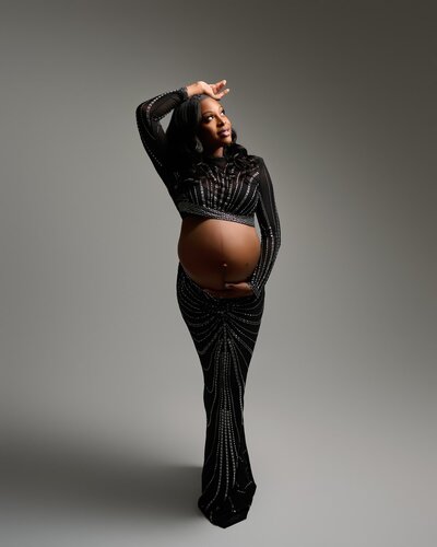 Bold maternity look with shimmering black pattern and high neckline