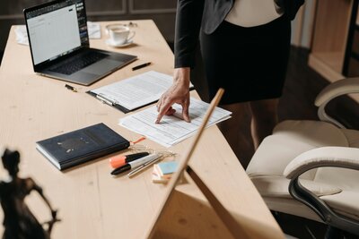 Woman reviewing and reading paperwork at desk