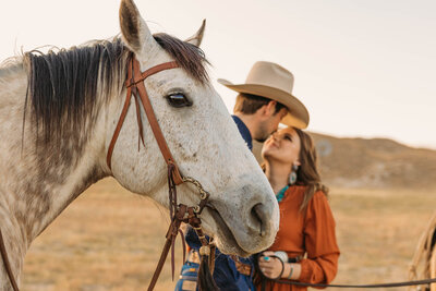 couple sitting on horses in desert