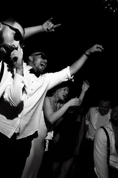 The groom and his groomsmen take over the dance floor, laughing and moving in sync—a high-energy moment of brotherhood and celebration.