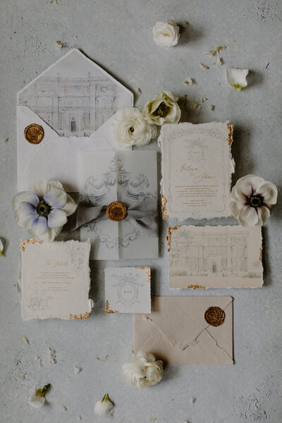 Wedding invitations and flowers laid out together 