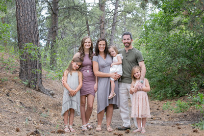 Family of 6 stop to pose for a photo in foothills outside of Denver