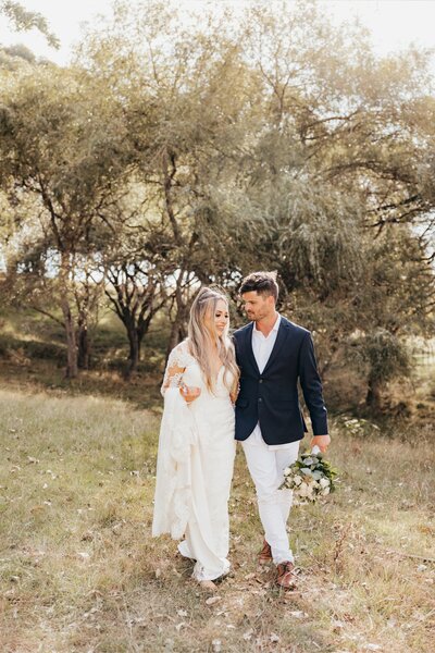 A bride and groom walking towards  the photographer during their wedding photoshoot with auckland photographer michelle kelly photography
