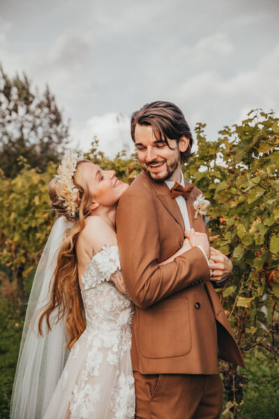 Newlywed couple pose in a vineyard