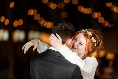 Bride groom first dance in barn with ceiling filled with twinkle lights