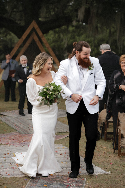 a bride and groom walk down the aisle in celebration on their wedding day in San Antonio, Texas.