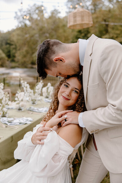 bride and groom posing on beach chairs