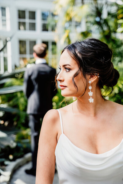 a bride looking over her shoulder about to see her fiancé for the first time