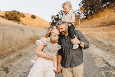 Family Snuggles together as they walk in the hills of Mount Diablo