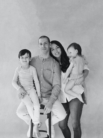 Family posing with backdrop in studio in all black and white film photo