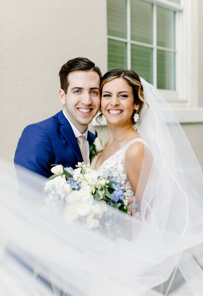 Bride and Groom standing close cheek to cheek with veil flowing below