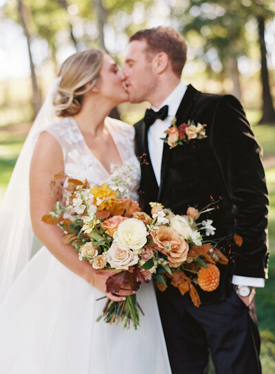 Low floral centerpieces for elegant wedding overflowing with white garden roses, ranunculus, butterfly ranunculus, scabiosa, lisianthus, sweet peas, and natural dark greenery. Floral hues of white, cream, and blush. Designed by Rosemary and Finch in Nashville, TN
