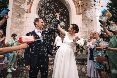 Les mariés célèbrent leur union à la sortie de l'église durant leur mariage en Auvergne.