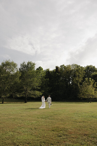 A couple walking toward a pond The Era Wedding & Event Venue