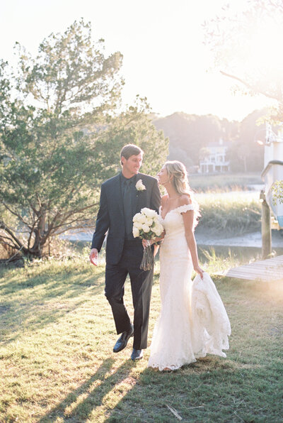 Bride and groom holding each other in a field overlooking a scenic mountain lake in Steamboat Springs Colorado