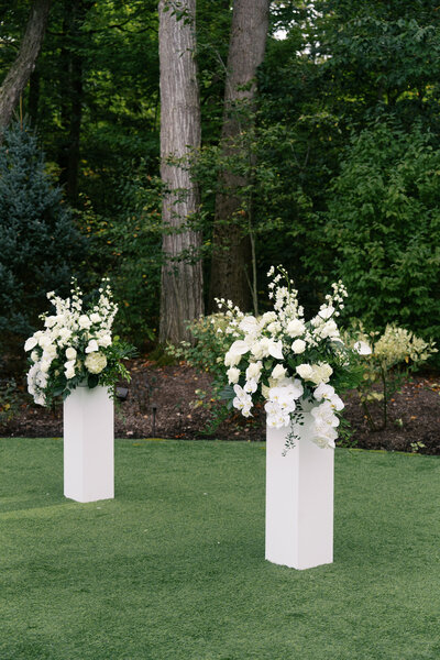 White floral arrangements on modern pillars at an outdoor wedding ceremony | Ohio wedding photographer