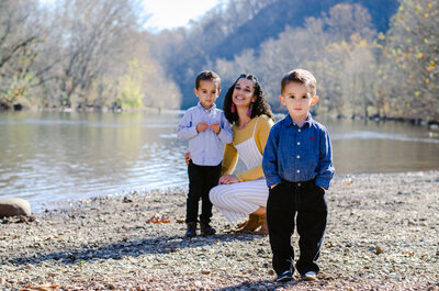 Mom and boys smiling near river