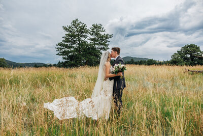 Boulder Wedding Photographer captures bride and groom hugging in field