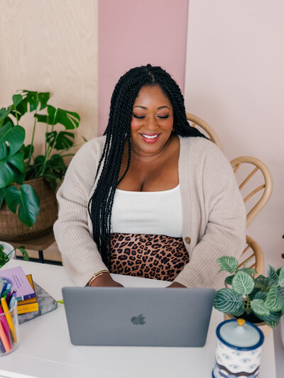 Woman business owner smiling and holding a laptop