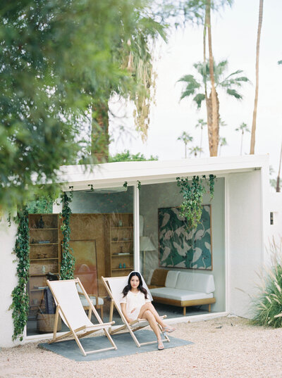 Bride sitting in sun chairs outside at elopement wedding venue in Palm Springs
