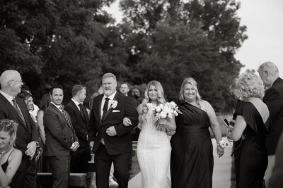 Bride walking down the aisle  with her mom and dad
