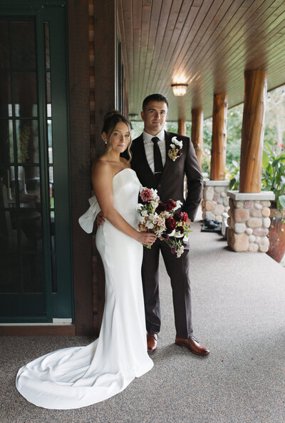 Bride and groom smiling softly at the camera during their wedding portraits for northern Minnesota backyard intimate wedding.  Captured by a Minnesota Wedding and Elopement Photographer specializing in couples looking for an intimate, documentary style wedding day coverage. 
