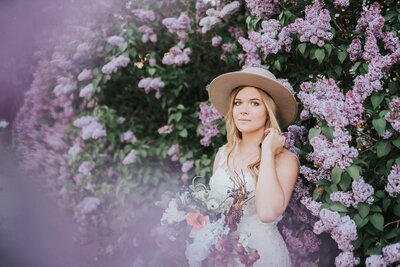 Lake Tahoe Elopement Photographer captures bride wearing boho hat in purple flowers