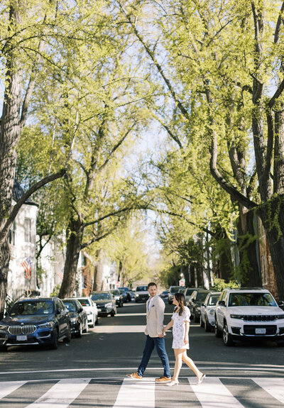 Engaged couple walks across the street in downtown Georgetown