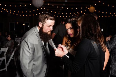 Photographer chatting with bride and groom during their reception about timeline