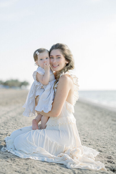 Miami family photographer Sandra Vallejo capturing mom holding daughter on the beach