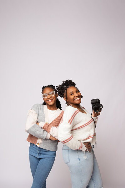 Mother & daughter posing back to back.