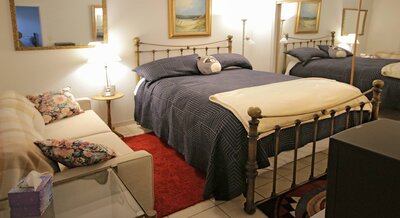 Bedroom with warm light, blue bedding and a red rug