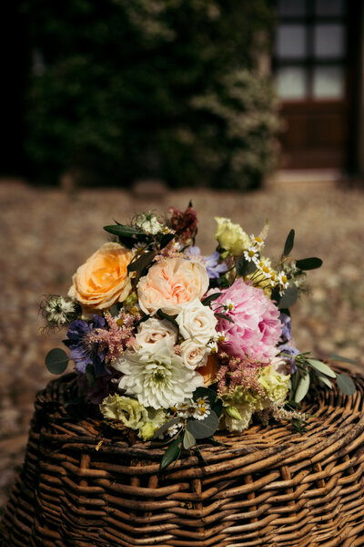 A colorful bouquet, blending vibrant blooms and natural textures, creating a charming and rustic floral arrangement that complements the wedding's lively and joyful atmosphere