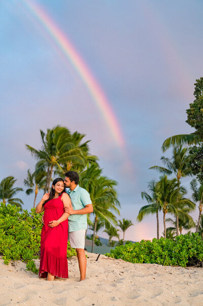 hawaii rainbow couples smiling at their maternity session on the beach