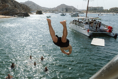 Bride and groom spinning on cabo san lucas beach