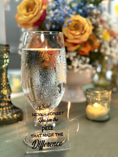Vibrant floral centerpiece with colorful blooms, surrounded by candlelight and a glass of water, creating a warm and elegant wedding tablescape