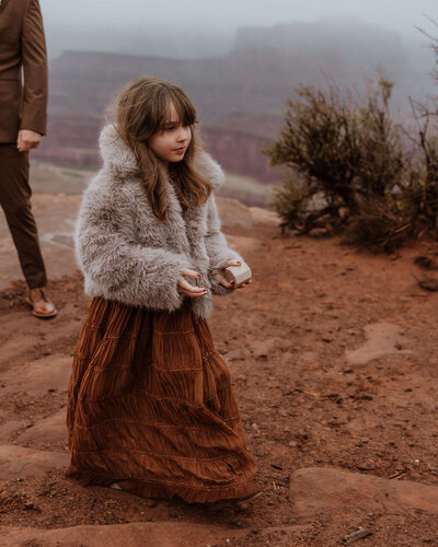 young girl standing in the desert at a wedding