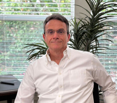 The founder and managing director with 30 years of experience in the financial sector. He is dressed in an elegant white shirt, reflecting professionalism and extensive expertise in financial consulting.