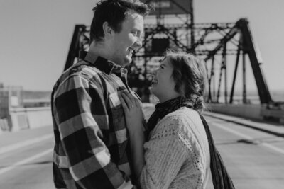 black and white image couple embracing on bridge