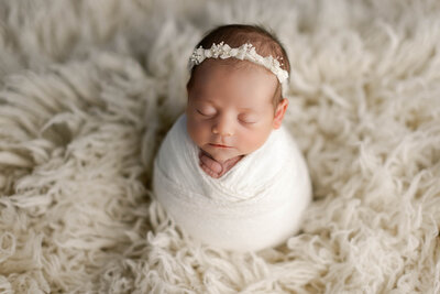 Chicago Newborn Baby girl in potato. pose with headband