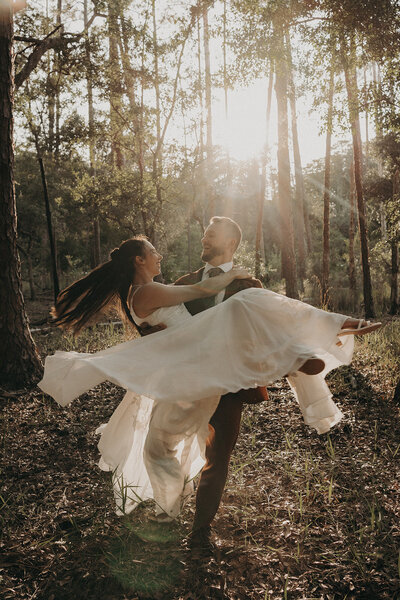 groom carrying bride spinning laughing together wedding day intimate outdoor elopement