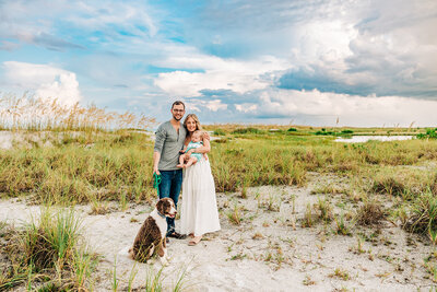 Family of three with thier dog on a beach near St. Pete FL