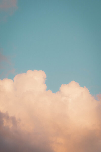 Soft pastel clouds at golden hour against a clear blue sky